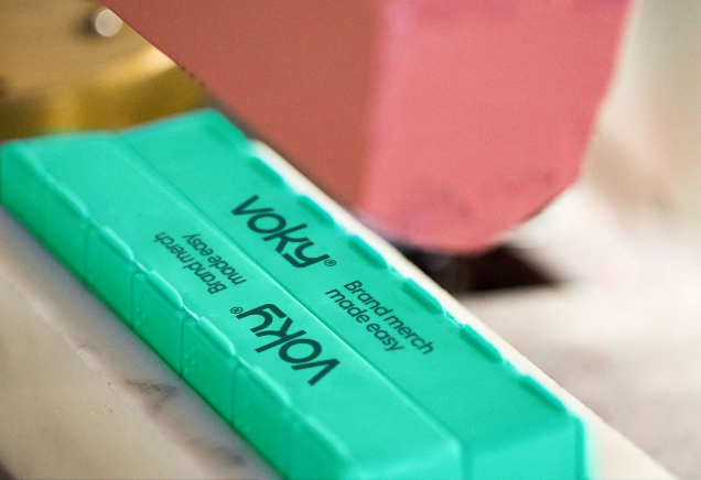 Voky-logotypen genomg&aring;r tampongtryck p&aring; en gr&ouml;n produkt